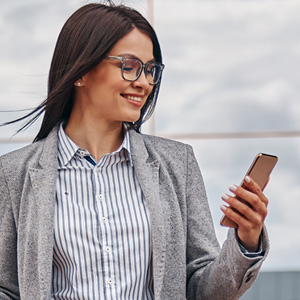 Student smiling while checking her phone during her move to study in the EU
