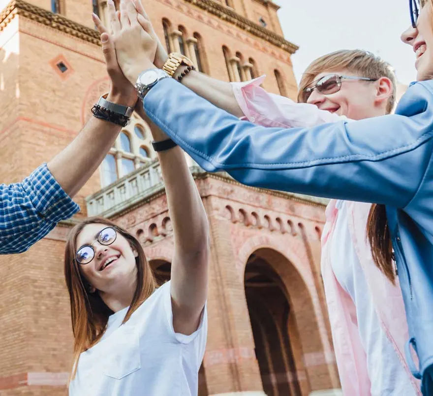 Students celebrating in front of a historic European university building